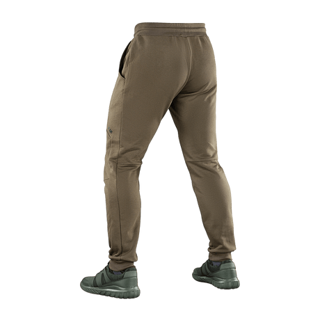 M-Tac Stealth Cotton -housut ruskeina, takaa nähtynä, kuminauha vyötäröllä ja sivutaskut, sporttinen tyyli liikkumisvapaudelle.