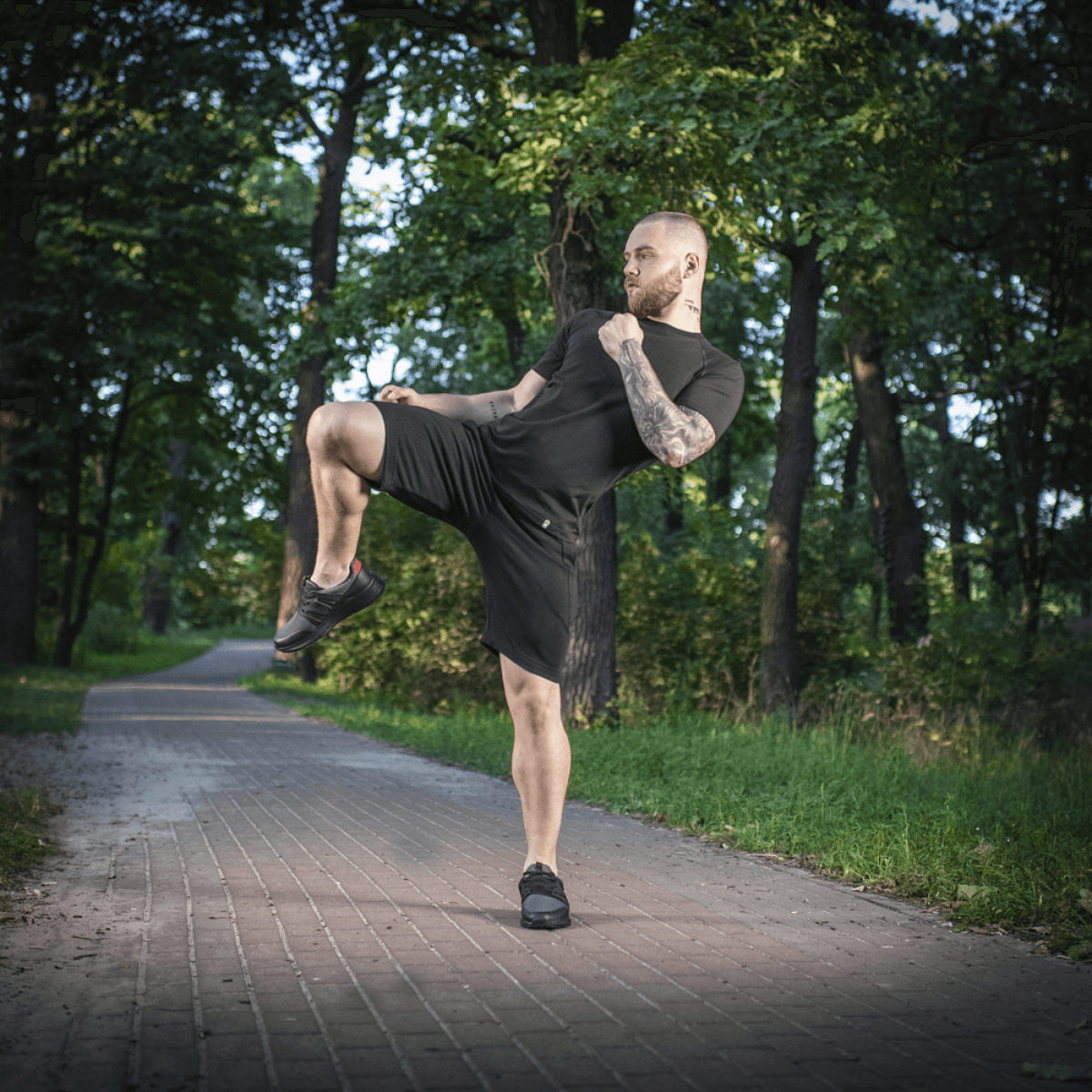 Mies treenissä metsässä M-Tac Shorts Casual Fit Cotton -shortseissa, mustat shortsit mukavalla istuvuudella ja hillityllä M-Tac-logolla.