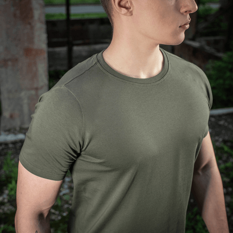 Mies pukeutuneena M-Tac T-shirt 93/7 Summer luonnossa, korostaa kevyttä ja hengittävää laatua kesäpäiviin.