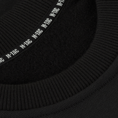 Yksityiskohta M-Tac Sweatshirt Cotton Hardista näyttää resorin ja heijastavan logon mustassa 100% puuvillamateriaalissa, tiheys 390 g/m².