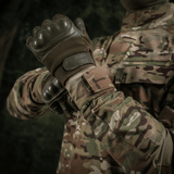 M-Tac Jakke Sturm NYCO Extreme Multicam-kuosissa, sotilastakki kestävästä nylon-puuvillakankaasta, esitetty luonnon maisemassa.