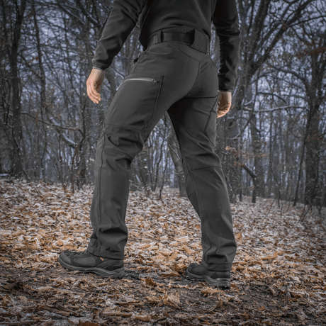 M-Tac Bukser Soft Shell Vinter metsäympäristössä, sopivat talvikäyttöön fleece-vuorella ja tuulen- ja vedenhylkivällä softshell-materiaalilla.