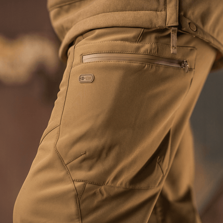 M-Tac Bukser Soft Shell Vinter ruskeana, fleece-vuori ja softshell-materiaali tuulen- ja vedenhylkimiseen, sivuprofiilista.