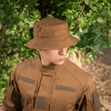 Mies, joka käyttää M-Tac Panama Rip-Stop army-hattua puolijäykkällä lipalla metsäympäristössä.