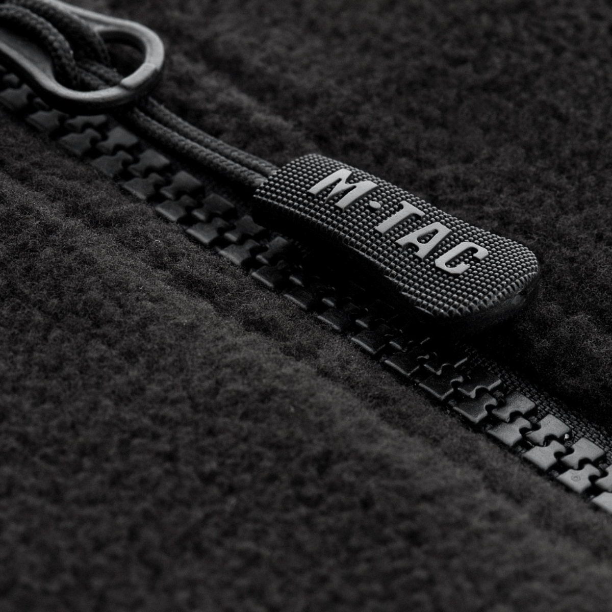 Lähikuva vetoketjusta M-Tac Alpha Microfleece Jakke Gen.II -takissa, näyttää kestävän fleecen ja laatudetaljit takissa.
