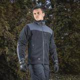 Mies pukeutuneena M-Tac Alpha Microfleece Jakke Gen.II -takkiin, täydellinen taktiseen ja ulkoilukäyttöön kylmällä säällä.