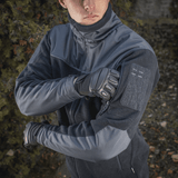 Henkilö pukeutuneena M-Tac Alpha Microfleece Jakke Gen.II tummissa sävyissä, sopii taktiseen ja ulkoilukäyttöön kylmällä säällä.