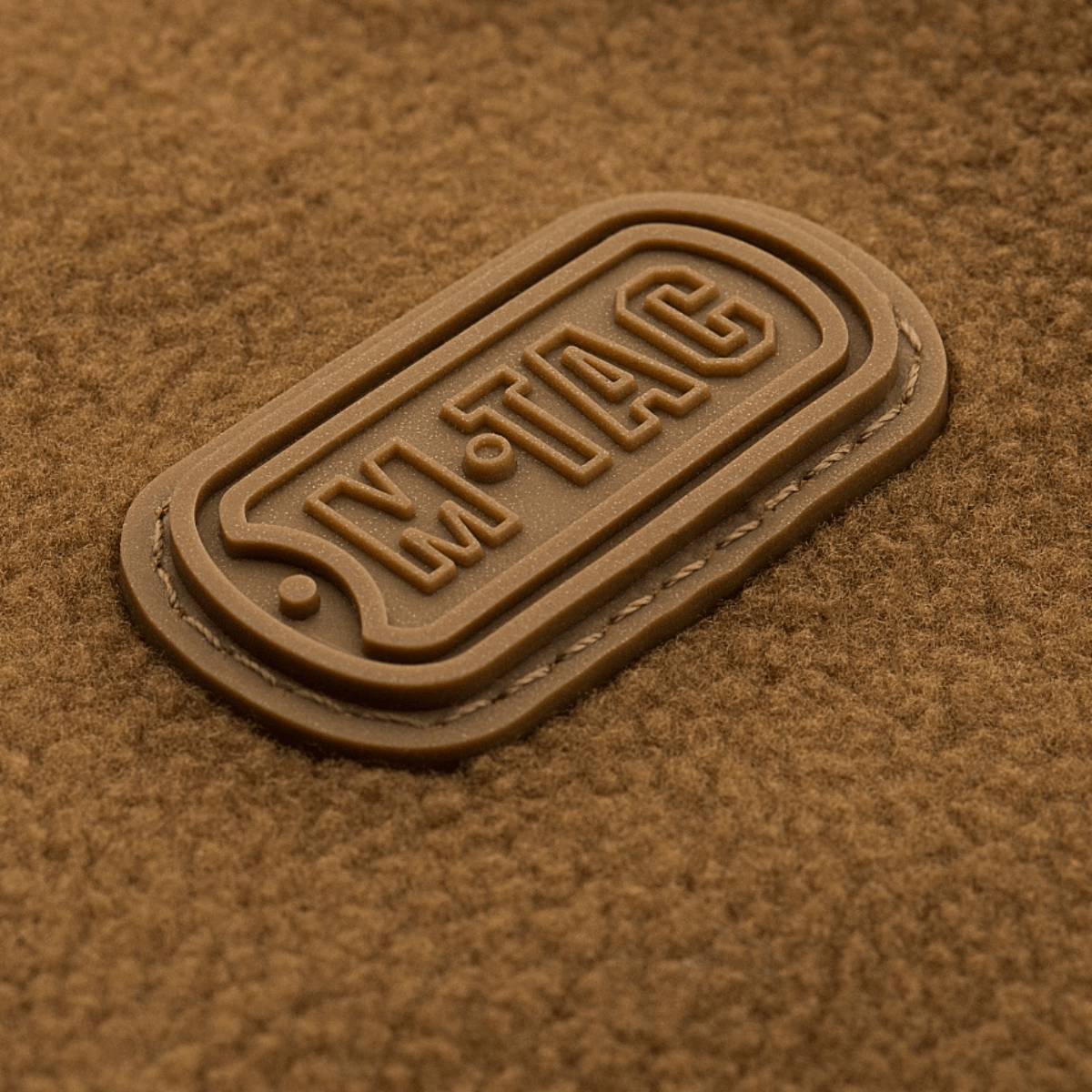 M-Tac Alpha Microfleece takki Gen.II -logo, korostaa edistynyttä muotoilua ja kulutuskestävyyttä kylmiin ulkoaktiviteetteihin.