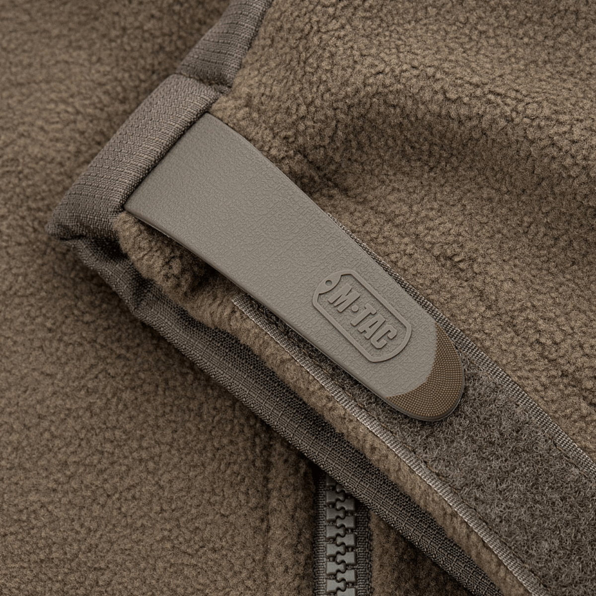 Yksityiskohta M-Tac Alpha Microfleece takista Gen.II, vahvistettu fleece ja Oxford-nylon olkapäillä, ihanteellinen kylmälle säälle ja ulkoilma-aktiviteetteihin.