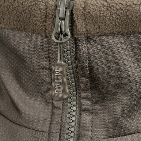 Vetoketjun yksityiskohta M-Tac Alpha Microfleece takki Gen.II:stä, suunniteltu taktiseen käyttöön ja ulkoilma-aktiviteetteihin kylmässä säässä.
