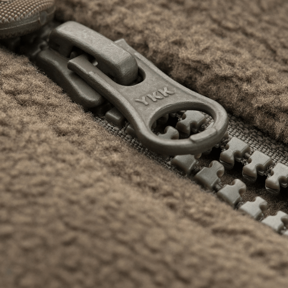 Lähikuva vetoketjusta M-Tac Alpha Microfleece takki Gen.II:stä, näyttää kestävät materiaalit lisäkulutuskestävyyteen kylmässä säässä.