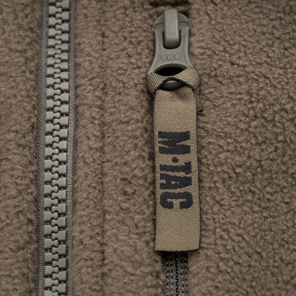 Lähikuva vetoketjusta M-Tac Alpha Microfleece takki Gen.II:stä, korostaa fleeceä ja kulutuskestävyyttä kylmässä säässä.