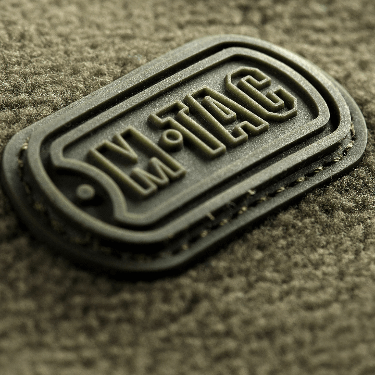 Lähikuva M-Tac Alpha Microfleece takista Gen.II, M-Tac-logo kestävässä fleecessä.