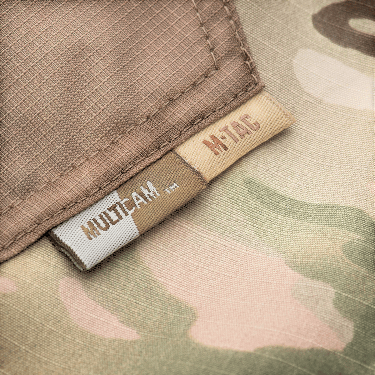 M-Tac housut Aggressor Elite NYCO multicam, ripstop-kangas ja yksityiskohtainen ommel, lähikuva merkeistä ja materiaalista, galleria-asento 1.