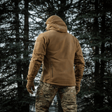 Mies pukeutuneena M-Tac Division Gen.II Windblock Fleecejakke metsässä, maksimaalinen lämpö ja tuulisuoja, 100% polyester.