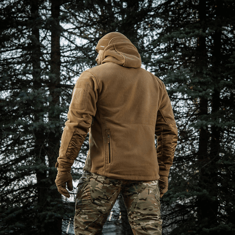 Mies pukeutuneena M-Tac Division Gen.II Windblock Fleecejakke metsässä, maksimaalinen lämpö ja tuulisuoja, 100% polyester.