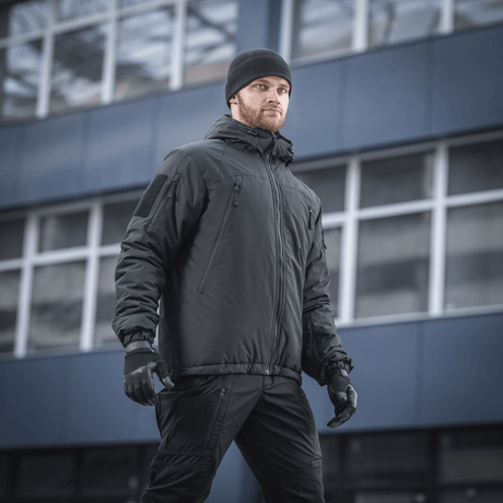 Mies pukeutuneena M-Tac Alpha Gen.III Pro talvitakkiin, suunnattu mukavuuteen ja toimivuuteen kylmässä säässä, sopii lämpötiloihin jopa -20°C.