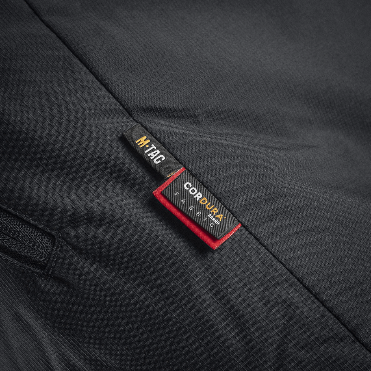 Lapussa M-Tac Alpha Gen.III Pro talvitakki, Cordura-yksityiskohtia mustassa kankaassa.