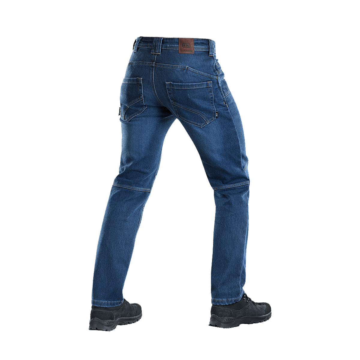 Takakuva M-Tac Jeans Tactical Gen. I Cordura Regular Fit, Cordura-denimhousut päivittäiseen ja taktiseen käyttöön, kuvattu saappaiden kanssa.