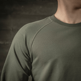 M-Tac Raglan Athlete oliivinvärisenä, minimalistinen college raglanhihoilla, sopii urheiluun ja arkipäivän käyttöön ympäri vuoden.