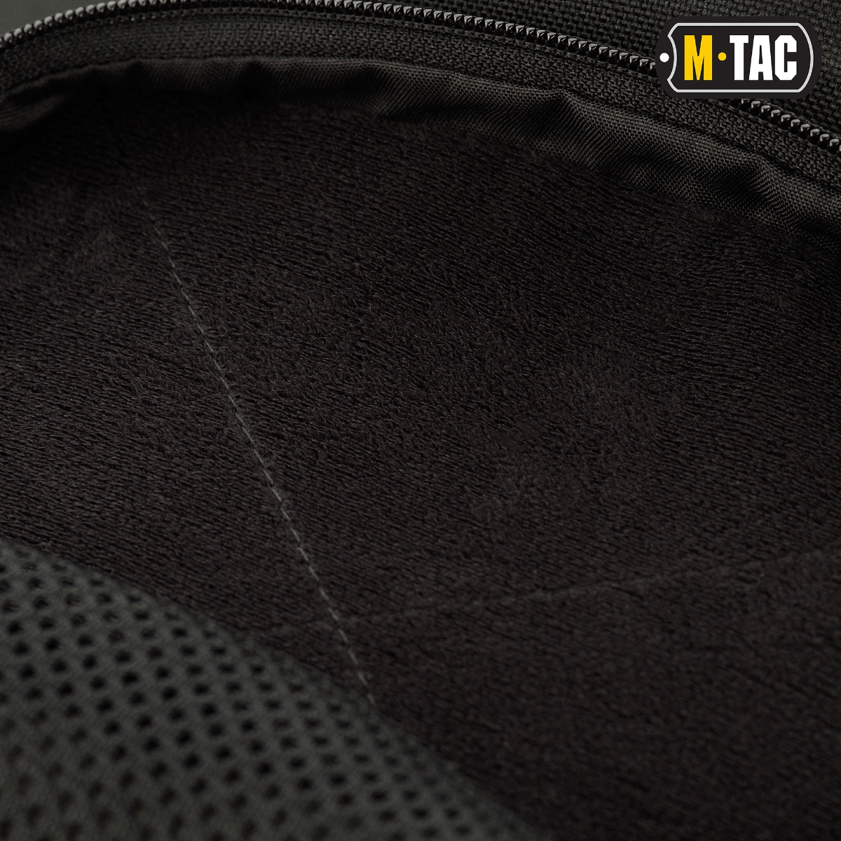 Lähikuva laukun sisäpuolelta M-Tac Buckler Taske Elite mustassa Cordura-materiaalissa pehmeällä toppauksella. Painopiste taktillisessa säilytyksessä.