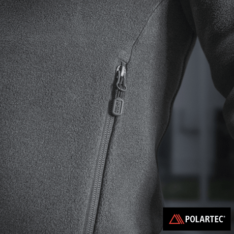 Lähikuva vetoketjun yksityiskohdasta ja Polartec®-logosta, valmistettu premium-lämmöneristävästä materiaalista.