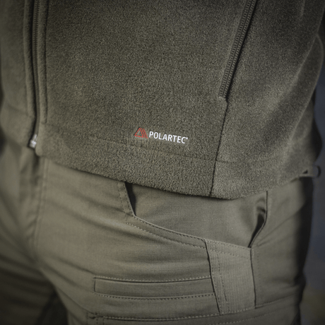 Lähikuva M-Tac Nord Polartec -fleecetakista Polartec®-logolla, näyttää takin harmaan mdl-värin yksityiskohtia.