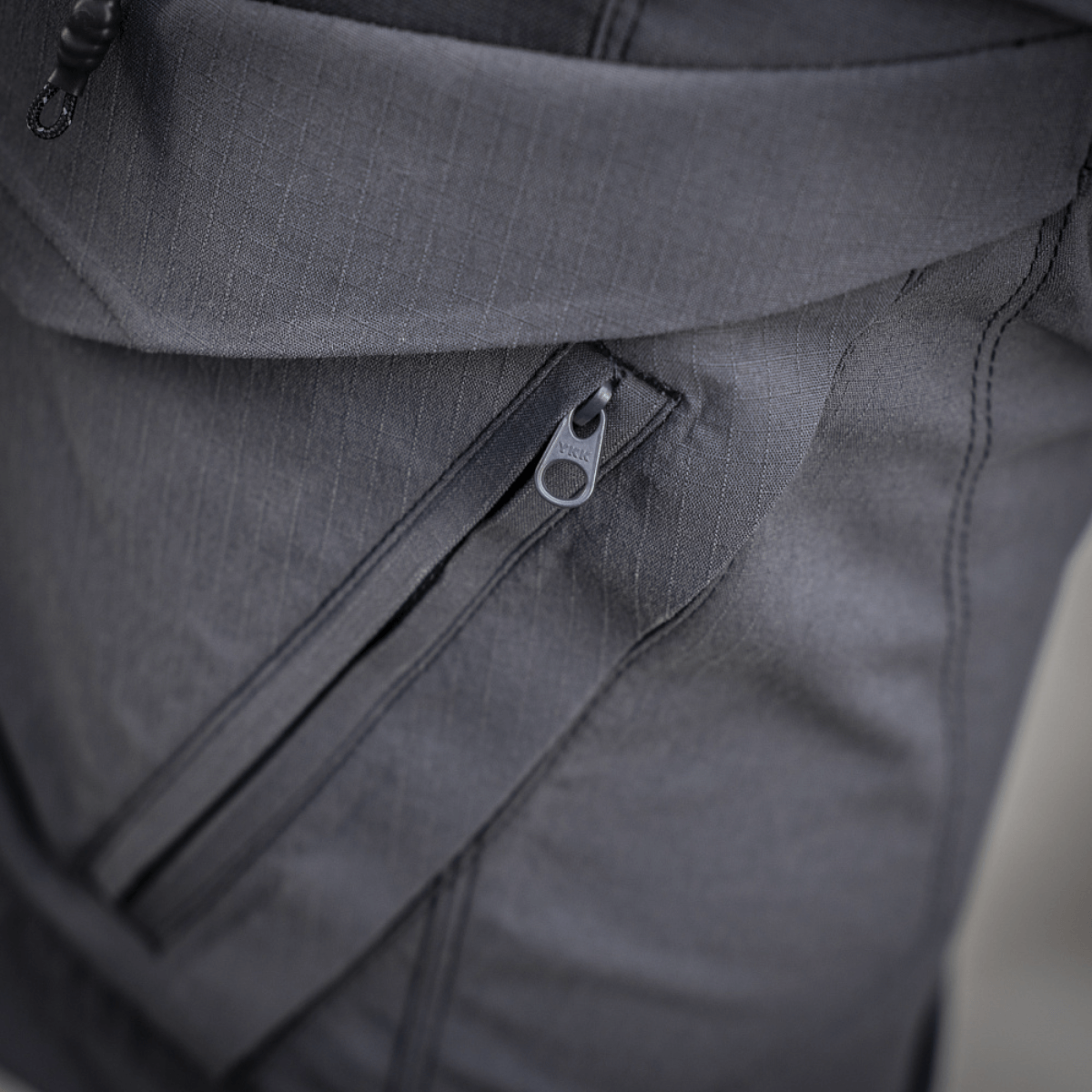 Lähikuva M-Tac Aggressor Summer Flex Shorts -vetoketjutaskusta ja Flex Rip-Stop -kankaasta, taktinen käyttö ja mukavuus.