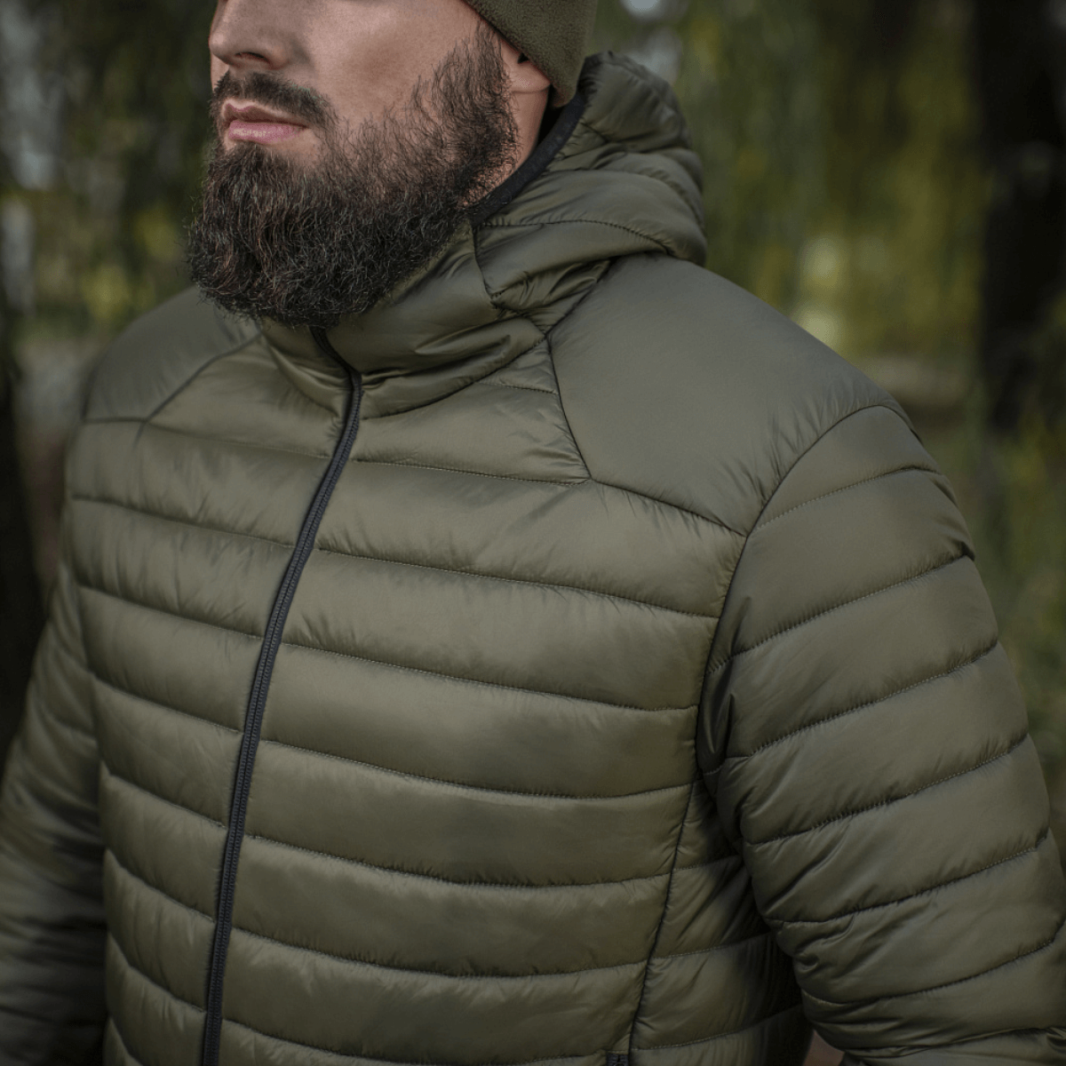 Henkilö pukeutuneena M-Tac Stalker Gen.III -takkiin luonnossa, sopii vaihtokaudelle G-LOFT-eristyksellä ja säädettävällä hupulla, mukavuus -15°C