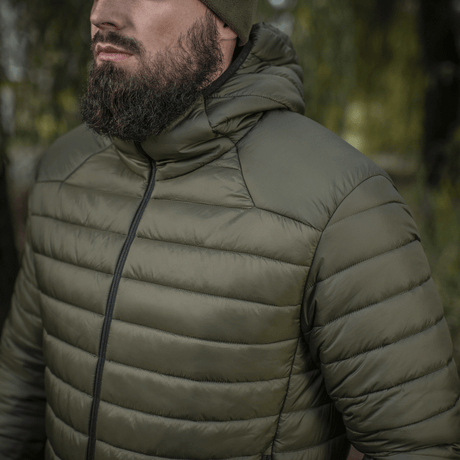 Henkilö pukeutuneena M-Tac Stalker Gen.III -takkiin luonnossa, sopii vaihtokaudelle G-LOFT-eristyksellä ja säädettävällä hupulla, mukavuus -15°C