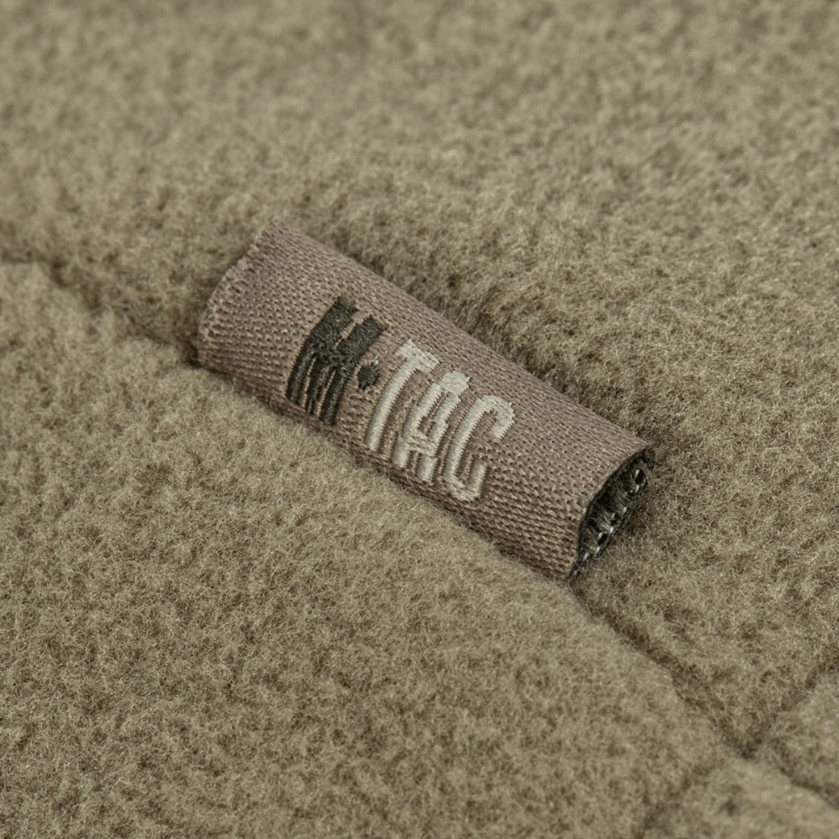 Lähikuva M-Tac Combat Fleece Polartec -takista, merkki fleecemateriaalissa korostaa laatua ja muotoilua.