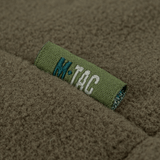 Lähikuva M-Tac Combat Fleece Polartec -takista merkin yksityiskohdilla, materiaalin tekstuuri sotilasvihreänä.