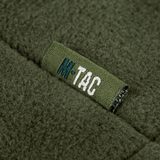 Yksityiskohta M-Tac Combat Fleece Polartec -takista merkin logolla oliivinvihreänä, näyttää muotoilun yksityiskohdat.