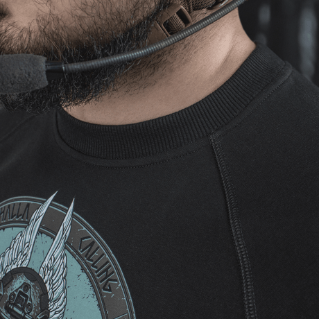 Mies pukeutuneena M-Tac Raglan Odin Mystery -paitaan, Odin-kuvio, musta raglan ja mukavat materiaalit rentoon tyyliin.