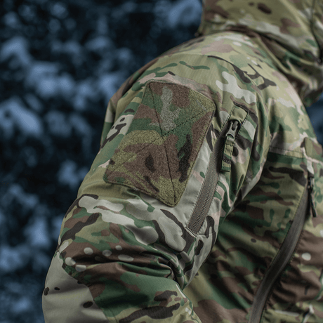Yksityiskohtainen kuva M-Tac Alpha Gen.IV Pro Primaloft -takista Multicam-designilla ja vettähylkivällä materiaalilla.