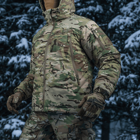 M-Tac Alpha Gen.IV Pro Primaloft -talvitakki Multicam-kuosissa lumisessa metsämaisemassa.