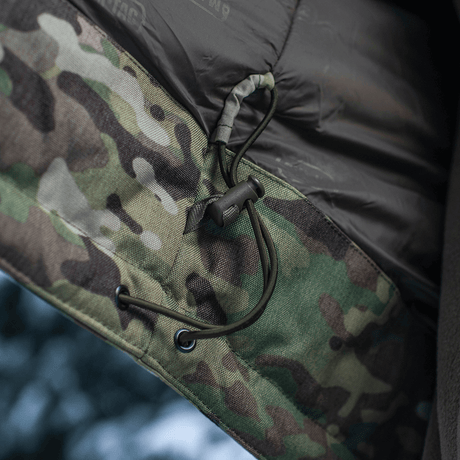 Yksityiskohta M-Tac Alpha Gen.IV Pro Primaloft -takista Multicam-kankaalla, näyttää nyörityksen premium-tason vettähylkivässä materiaalissa.