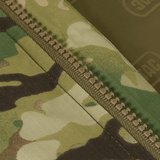 Yksityiskohta M-Tac Alpha Gen.IV Pro Primaloft -talvitakista Multicam-kankaalla ja vetoketjulla.