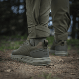 M-Tac Aggressor Summer Flex -housut metsäympäristössä, näyttää lahkeen ja kengän yksityiskohtia