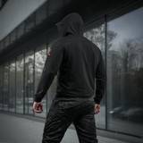 M-Tac Hoodie Freedom nähtynä takaa urbaanissa ympäristössä, näyttää hupun ja istuvuuden, sopii arkeen ja aktiiviseen ulkoiluun.