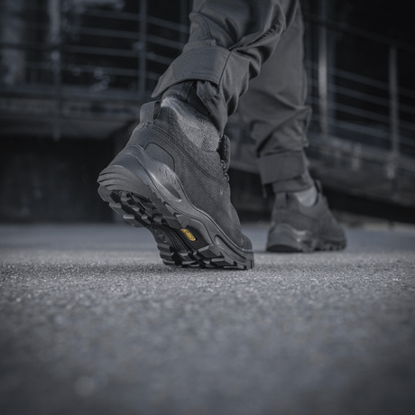 Mies kävelee betonipinnalla M-Tac Tactical Sneakers Patrol R Vent -kengät jalassaan, näkyy kestävä kumipohja.