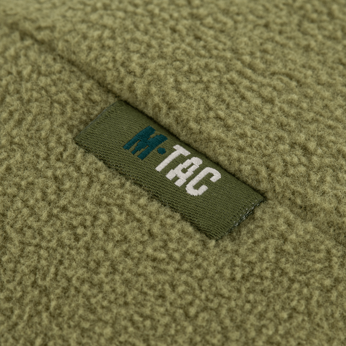 Lähikuva M-Tac Watch Cap Elite Fleece Beanie Hat Slimtexistä, logo armeijanvihreässä fleecessä