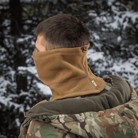 Henkilö käyttää M-Tac Anatomisk Snood Justerbar Elite Fleece (320 g/m²) luonnossa, suunniteltu suojaamaan kylmältä ja tuulelta.
