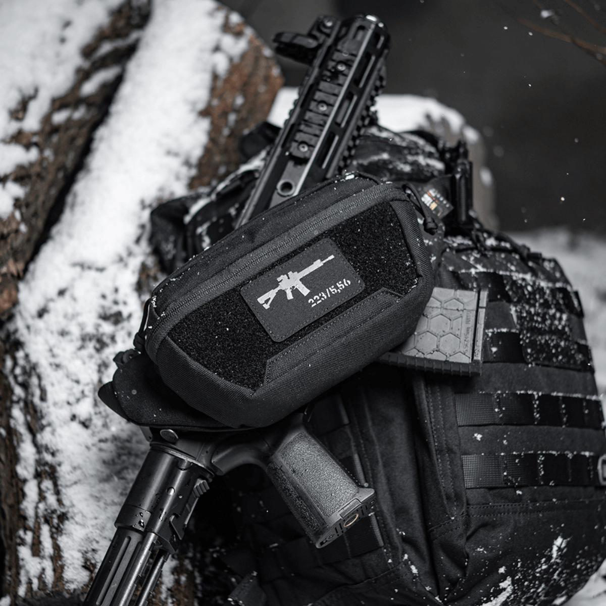 M-Tac AR-15 223/5,56 Laser Cut Patch, kiinnitetty taktiseen laukkuun lumisessa ympäristössä, kestävä patch sotilaalliselle, airsoft- ja ulkoilmakäyttöön, Velcro-kiinnitys.