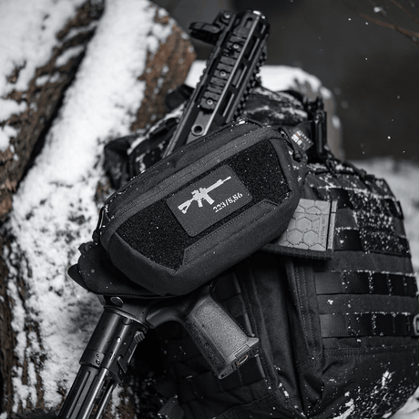 M-Tac AR-15 223/5,56 Laser Cut Patch, kiinnitetty taktiseen laukkuun lumisessa ympäristössä, kestävä patch sotilaalliselle, airsoft- ja ulkoilmakäyttöön, Velcro-kiinnitys.