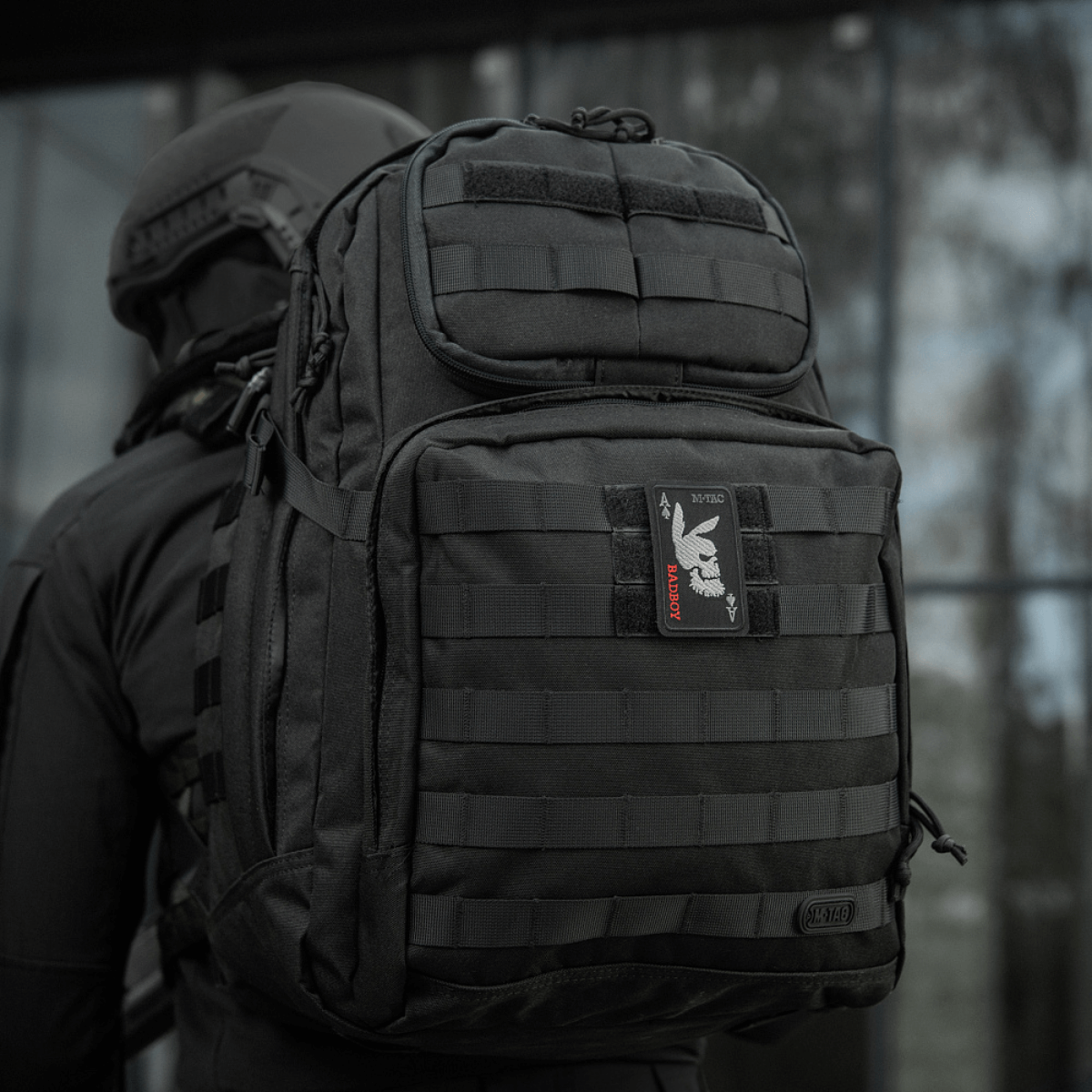 M-Tac Patch Bad Boy (kirjonta) kiinnitetty mustaan taktiseen reppuun, en, näyttää ace of spades -kuvion koiran kallolla.
