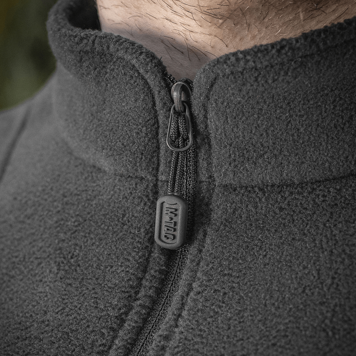 Lähikuva M-Tac Delta Polartec fleece-takin vetoketjusta ja Polartec® fleece-kankaasta.