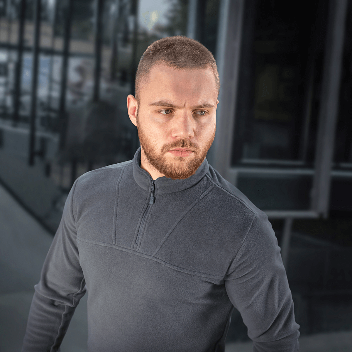 Mies pukeutuneena M-Tac Delta Polartec -fleece-takkiin, harmaa, puolivetoketjulla.