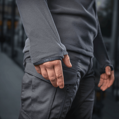 Mies pukeutuneena M-Tac Delta Polartec -fleece-takkiin; näkyy taskun yksityiskohta.