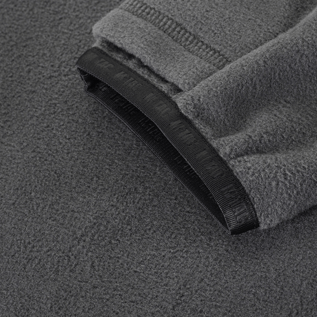 Lähikuva M-Tac Delta Polartec -fleece-takin kangasdetailista harmaana, korostaen rakennetta ja reunoja.